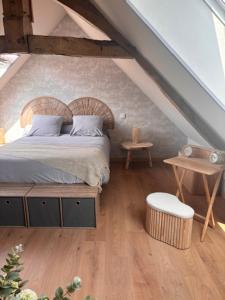 a bedroom with a bed in a attic at Le Cottage d'Emmy - Rose in Commes