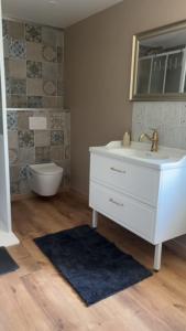 a bathroom with a white sink and a toilet at Le Cottage d'Emmy - Rose in Commes +11 photos