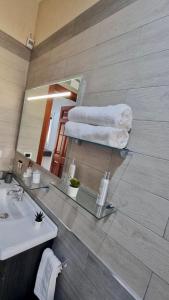 a bathroom with a sink and a mirror and towels at Relax House - vicino al centro, lontano dal caos in Casalnuovo di Napoli