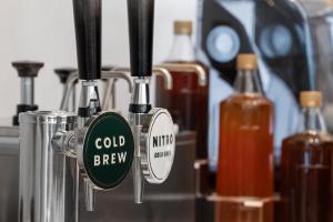 a close up ofcold brew bottles on a machine at The Westin Atlanta Gwinnett in Duluth
