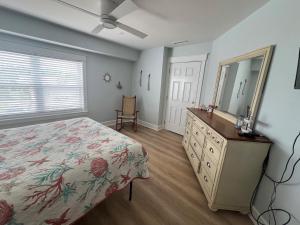 a bedroom with a bed and a dresser and a mirror at Boston Commons Penthouse Condo in Myrtle Beach