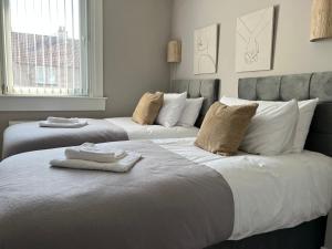 a bedroom with two beds with towels on them at Spacious Luxury 3 Bedroom Flat in Kirkcaldy, Fife in Fife