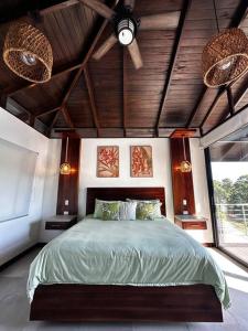 une chambre avec un lit et un ventilateur de plafond dans l'établissement Casa Ventanas Matapalo Luxe Villa, à Cabo Matapalo