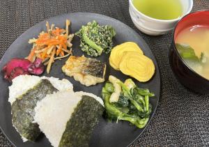 a plate of food with vegetables and other foods at Smile Hotel Tokyo Nishikasai in Tokyo