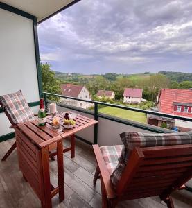 a balcony with a table and chairs and a view at Ferienwohnung HAGEBUTZE Entspannung pur mit Sauna-Poolzugang in Bad Lauterberg +44 photos
