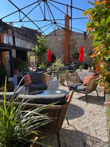 a patio with chairs and couches in a courtyard at LAROZIERE Chambres d’hôtes in Wimereux