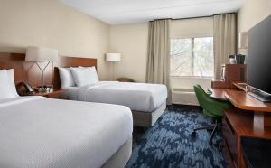 a hotel room with two beds and a desk at Fairfield by Marriott Inn & Suites Wallingford New Haven in Wallingford