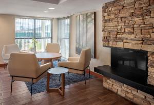 a waiting room with chairs and a fireplace at Fairfield by Marriott Inn & Suites Wallingford New Haven in Wallingford