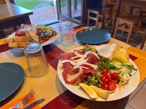 a table with two plates of food and a salad at Bed & Breakfast Casale Gregoriano and Apartaments in San Gimignano