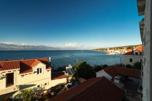 uma vista para a água a partir de um edifício em Taverna & Rooms em Sutivan