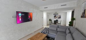 - un salon avec un canapé et une télévision murale dans l'établissement Luxury apartment near TGV station and the beach, à Tanger