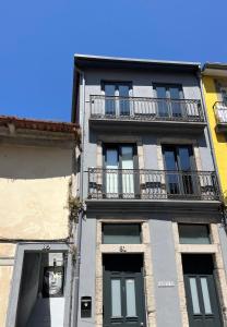 ein hohes Gebäude mit Balkon an der Seite in der Unterkunft A Muralha in Porto