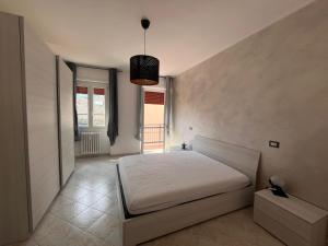 una camera da letto con un letto bianco e una finestra di Lady's home a Piedimulera