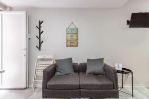 Chalé do Vale في بينهال نوفو: أريكة في غرفة معيشة مع ساعة على الحائط