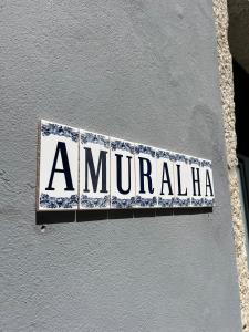 een bord aan de zijkant van een gebouw bij A Muralha in Porto