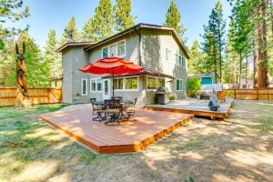 Casa con terraza de madera con mesa y sombrilla en Serene Nevada Retreat with Deck, Grill and Hot Tub!, en Stateline