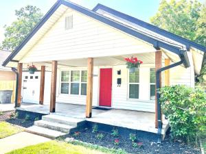 a small white house with a red door at Old Town Charm with 2 Bedrooms, 3 TVs in Lawton