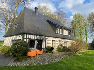 a house with orange chairs in front of it at Maison 10p avec piscine, chauffée et partagée avec 1 autre gîte, horaires privatifs pour chaque gîte - Réservation sur https auxportesdetretat fr in Villainville