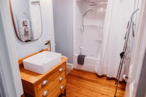uma casa de banho branca com um lavatório e um espelho em The Montague Rose Inn & Cafe em Saint Andrews