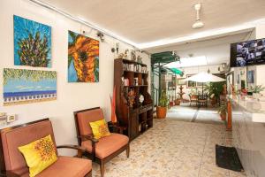 Habitación con 2 sillas y pinturas en la pared. en Vallarta Jr Suites en Puerto Vallarta