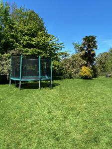 a sign sitting in the grass in a field at Maison 10p avec piscine, chauffée et partagée avec 1 autre gîte, horaires privatifs pour chaque gîte - Réservation sur https auxportesdetretat fr in Villainville
