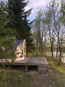 Pušų gaudyklė في Ginučiai: خيمة الجلوس على طاولة نزهة في الغابة