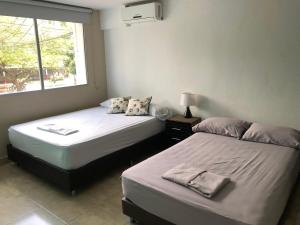 - deux lits assis l'un à côté de l'autre dans une pièce dans l'établissement Hotel Aqua lux, à Medellín