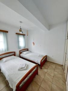 two beds in a room with white walls at Amorgos Aegean Heaven in Amorgos