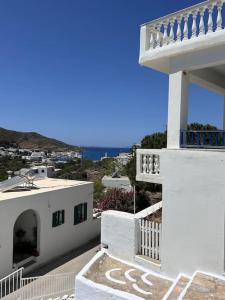 a white house with a staircase and a balcony at Amorgos Aegean Heaven in Amorgos