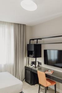 a hotel room with a desk and a bed at Grand Brizo Bel Air in Buenos Aires