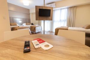 una habitación de hotel con una mesa con mando a distancia en Intersur Suites en Buenos Aires