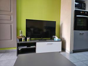 uma sala de estar com uma televisão de ecrã plano na parede em Ni 100%Gite,Ni100% loc chez Kheira&Pascal em Vitrolles