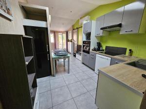 uma cozinha com electrodomésticos brancos e paredes verdes em Ni 100%Gite,Ni100% loc chez Kheira&Pascal em Vitrolles