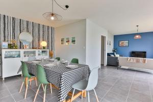 een eetkamer met een tafel en groene stoelen bij Serpentine, à 5mn des plages in Saint-Hilaire-de-Riez +12 foto's