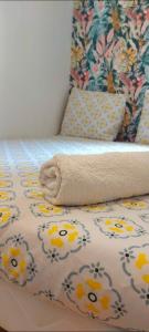 a bed with a comforter with a towel on it at Logement de standing à 9min du centre de Paris in Colombes