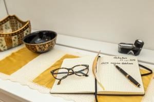 a pair of glasses and a pen on a table at Nonna ADELINA a 150 m da Cala Moresca in Àrbatax