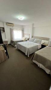 um quarto com três camas e uma tv nele em Hotel Plaza Formosa em Formosa