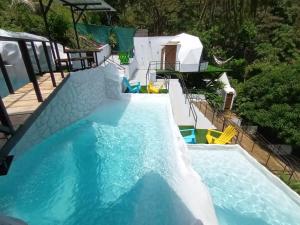 uma piscina com escorrega aquático em Glamping Tomaselli em Manuel Antonio