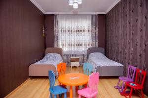 Cette chambre comprend deux lits, une table et des chaises. dans l'établissement Harmony Haven House, à Shaki