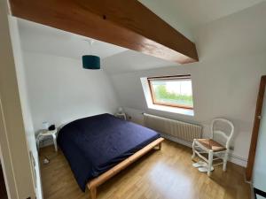 a bedroom with a blue bed and a window at Charmante Maison - Idéalement Située in Ronchin