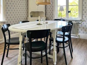 cocina con mesa blanca y sillas negras en 8 person holiday home in Varg n en Västra Tunhem