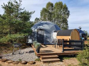 a yurt with a table and chairs on a wooden deck at Podniebny Glamping in Borsk