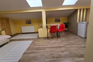 a room with two red chairs and a table at City Center Stay Apartament cu Parcare Modern & Liniștit in Iaşi