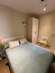 a bedroom with a bed with two pillows and a cabinet at Cal Music in El Poblenou del Delta