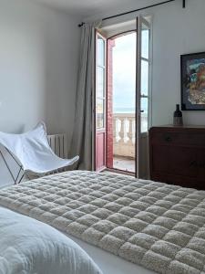ビダールにあるVilla Anvers Guetharyのベッドルーム1室(ベッド1台付)、スライド式ガラスドアが備わります。