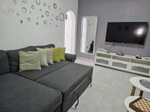 a living room with a couch and a flat screen tv at Casa Kevin in Puerto de Mogán