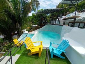 a group of chairs sitting next to a swimming pool at Glamping Tomaselli in Manuel Antonio