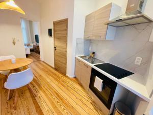 a kitchen with a sink and a table in a room at Chaleureux petit appartement in Liège +2 photos