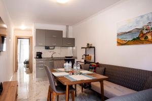 a kitchen and a dining room with a table and a kitchen gmaxwell gmaxwell gmaxwell gmaxwell at Sun & Sea Apartments in Nea Kalikratia