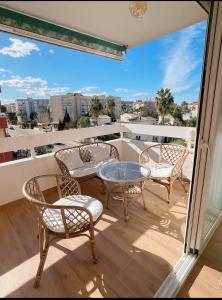 balcón con mesa de cristal, sillas y vistas. en Apartamento Boho Chic, en Denia